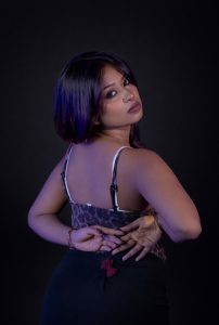 Confident woman posing in studio lighting with a stylish outfit and elegant posture