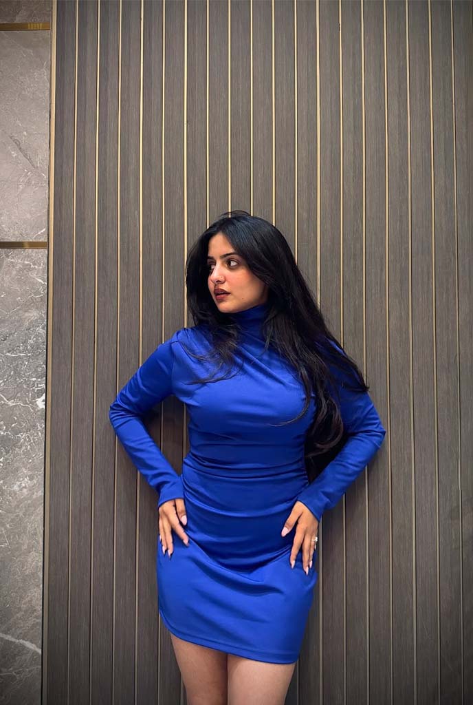 Aashini High-Profile Escort posing in a royal blue bodycon dress, showcasing elegance and luxury presence in Siliguri.