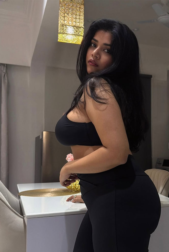 Yamini Hot Escort in fitted black attire highlighting her confident personality indoors