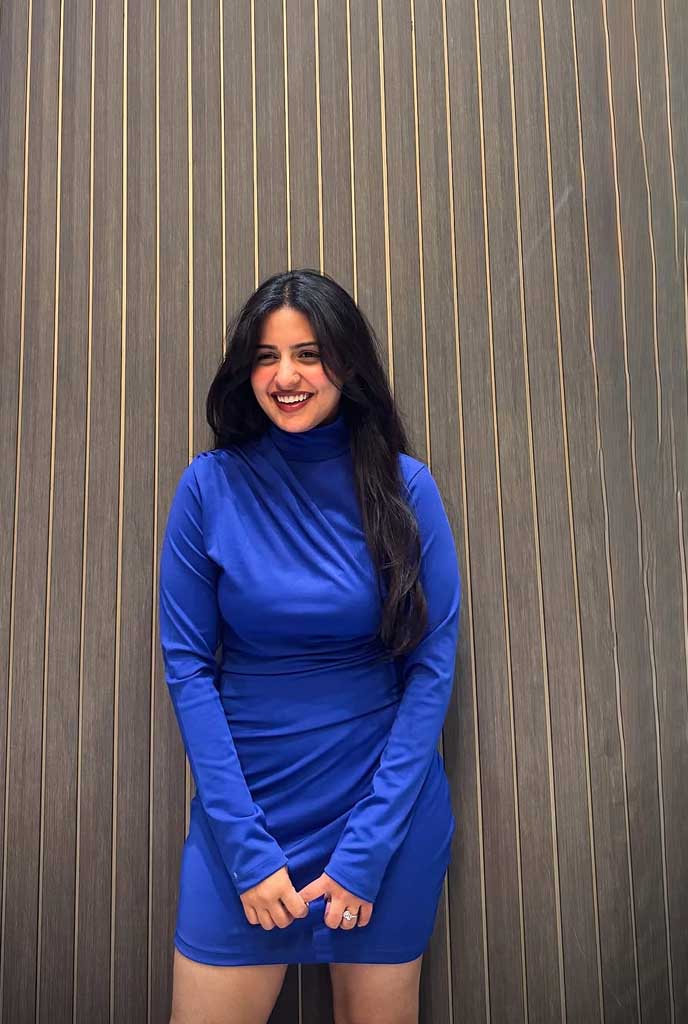 Aashini High-Profile Escort smiling gracefully in a stylish blue dress, reflecting sophistication and high-end escort experience in Siliguri.