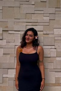 Laboni High-Profile Escort posing elegantly in a stylish black dress with floral hair accessory