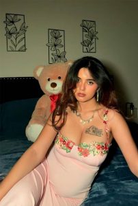 Noor Hot Escorts sitting gracefully in floral pink dress indoor setting