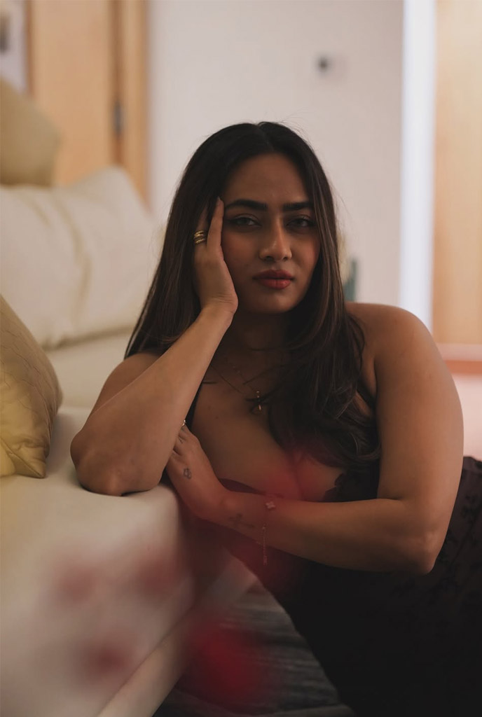 Swastika Sexy Escorts in sophisticated black attire with alluring indoor vibe