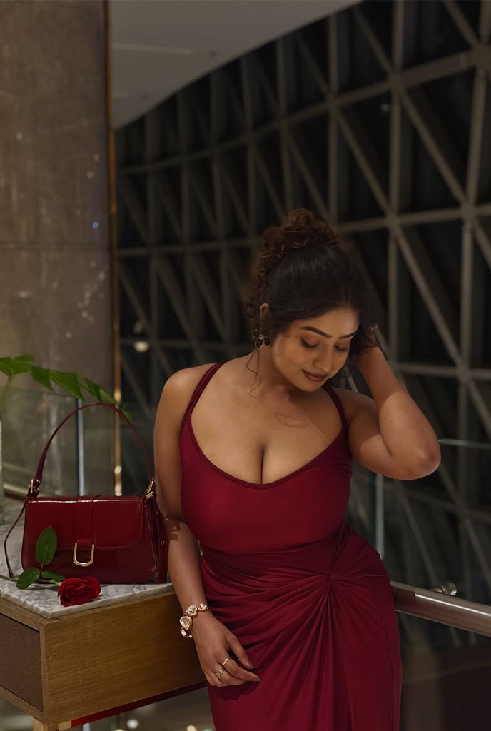 Nilisha Busty Escort in a sophisticated red gown showcasing elegant style and confident personality