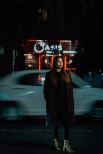 Ritika VIP Escort full body night portrait on a Siliguri street with moving car blur and neon city background